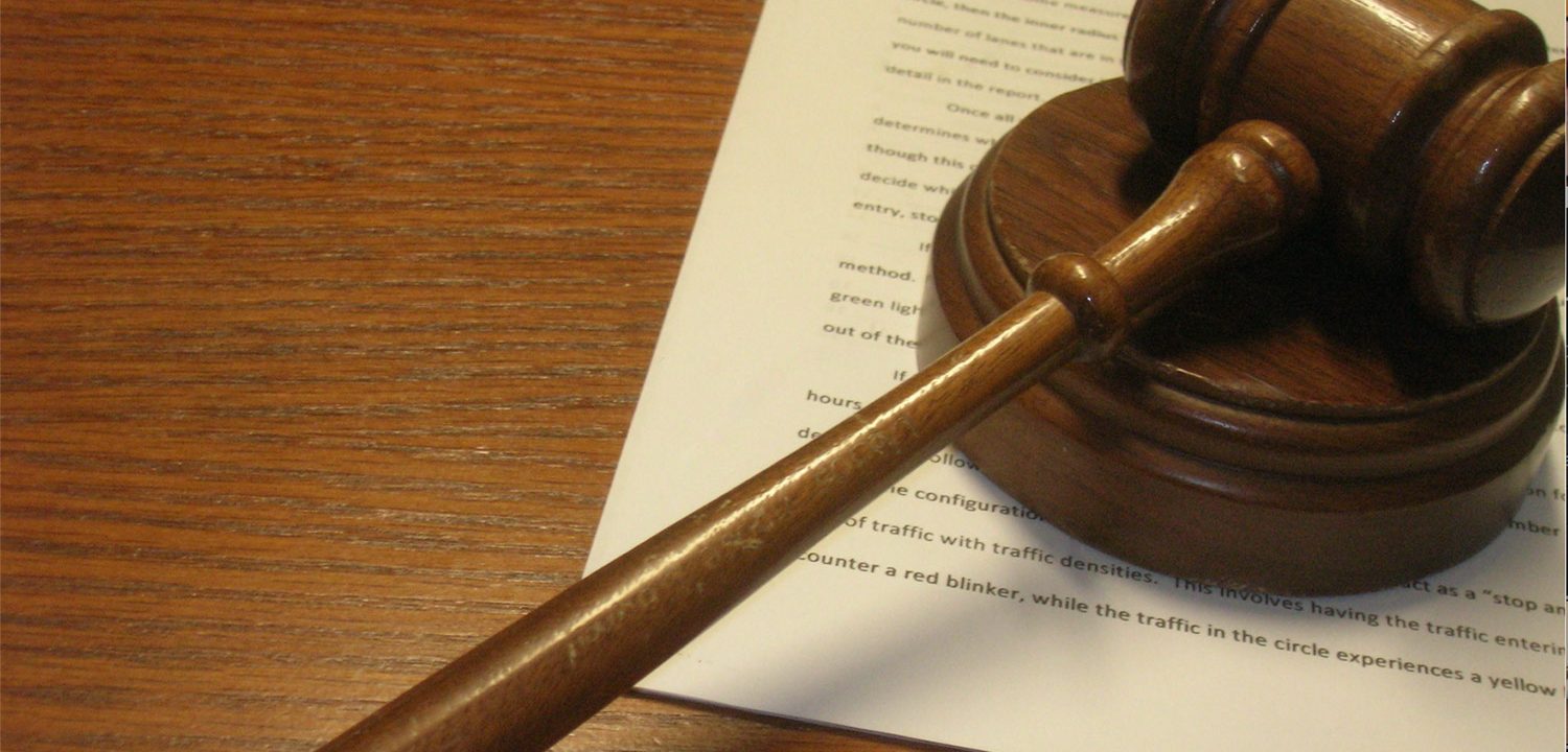 A gavel rests on a block sitting atop an incident report.