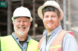 Two workers look into the camera and smile.