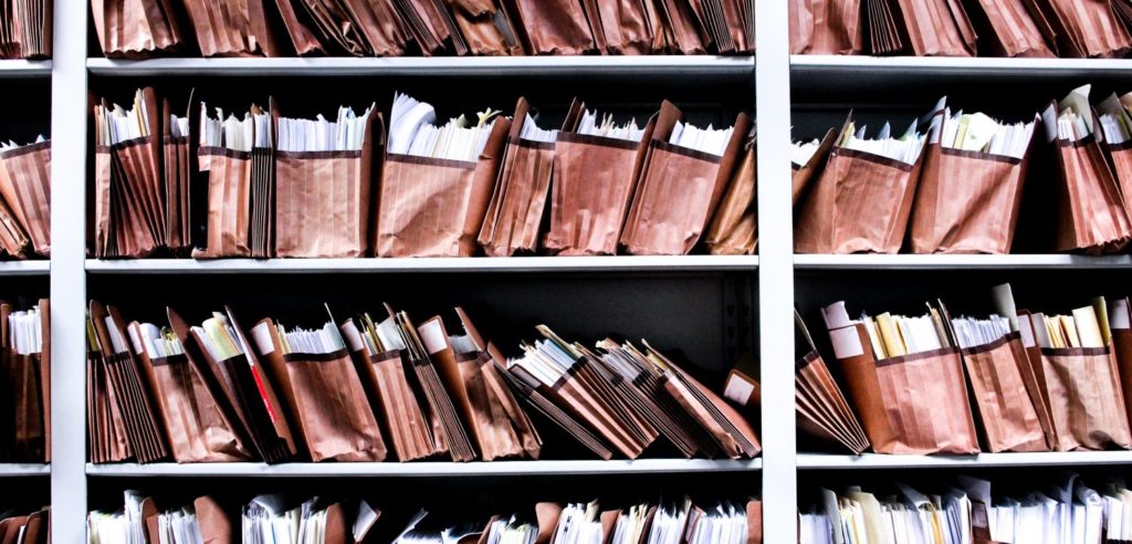 Several shelves are filled with organized folders of legal documents.