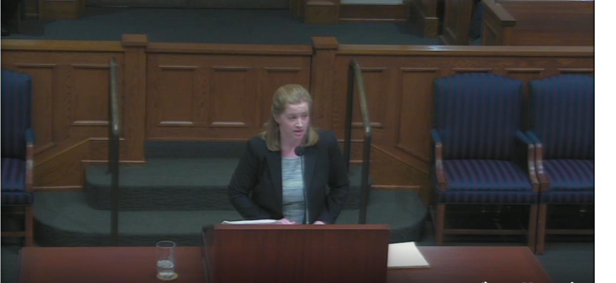 Lindsey Rowland stands at a podium and addresses the Supreme Court.