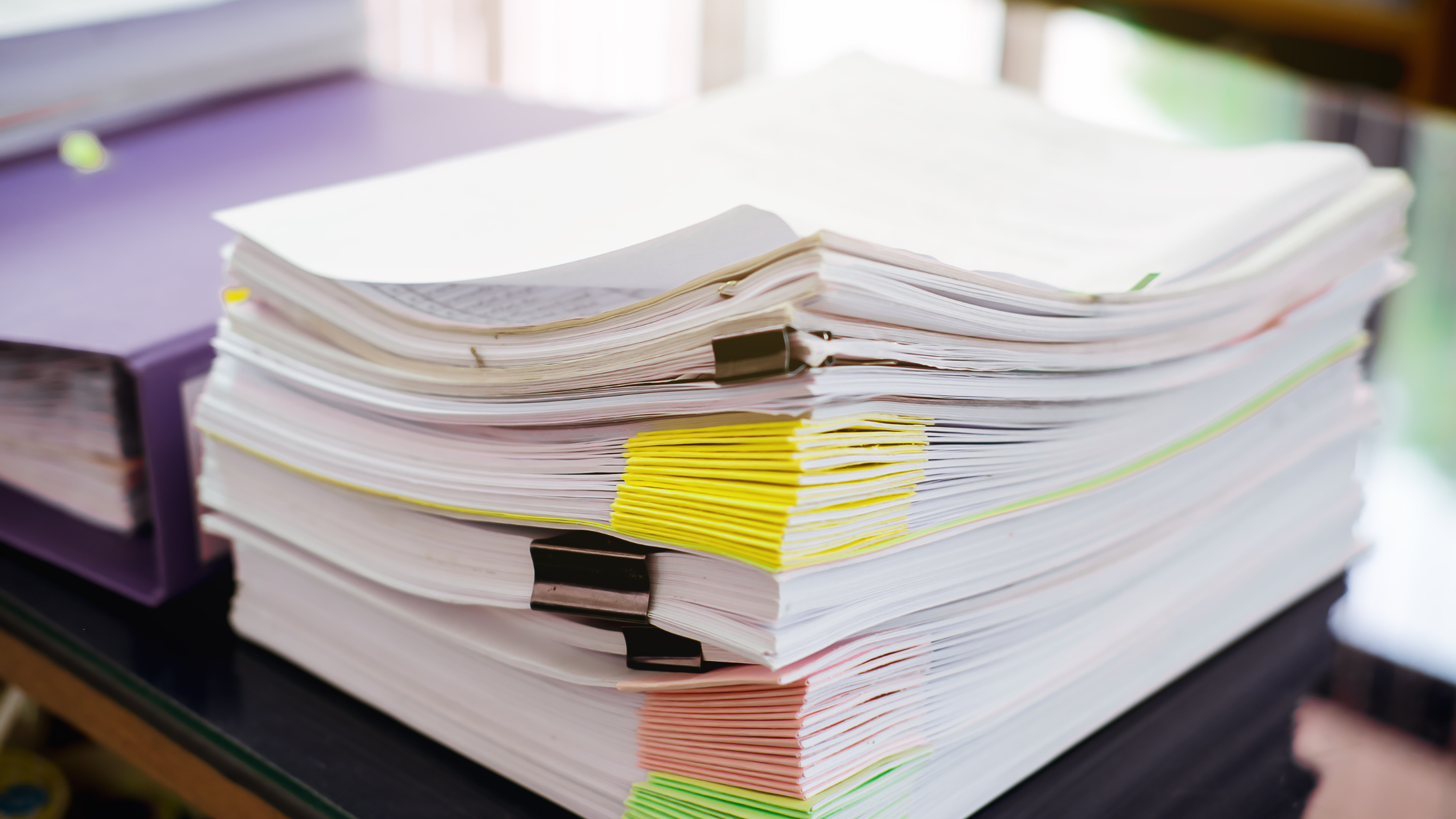 A Stack of Neatly Sorted Paper Files Sitting on a Table.