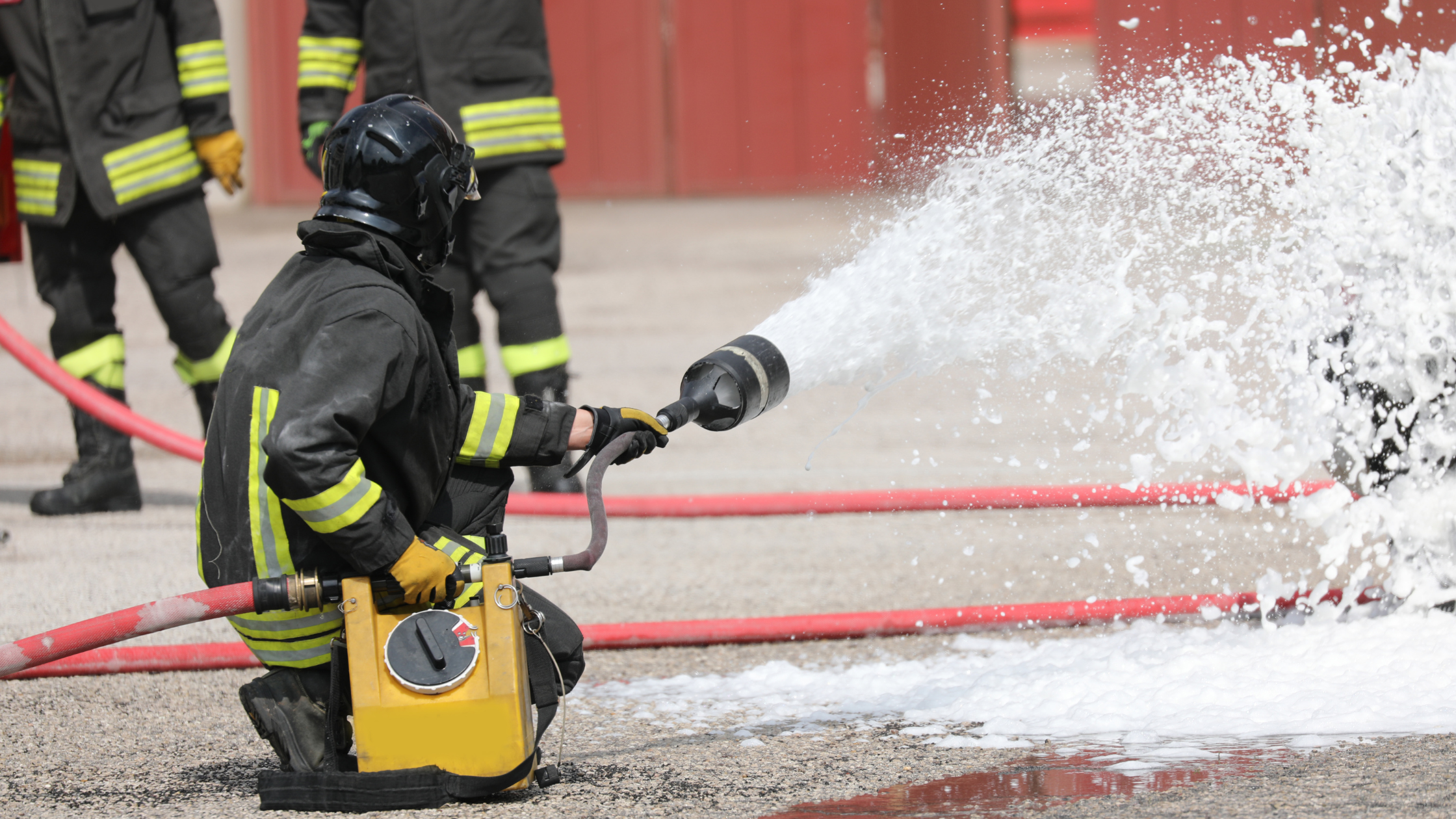 A firefighter spraying Aqueous Film-Forming Foam (AFFF) during a training exercise.